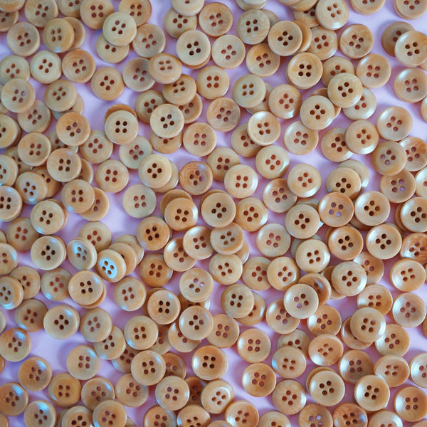 Close-up of beige buttons on a pink background