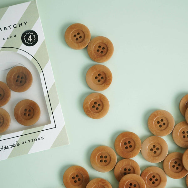 Brown buttons with a box labeled 'Matchy Club' on a light green background