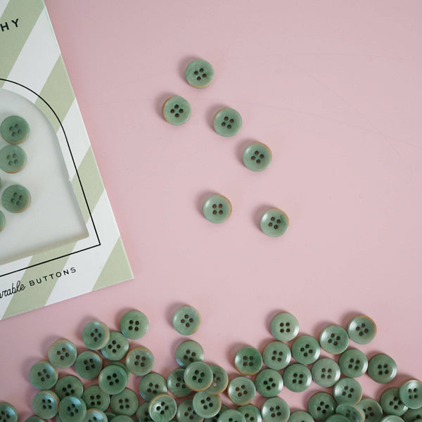 Green buttons on a pink surface with a box labeled 'Buttons' in the corner.