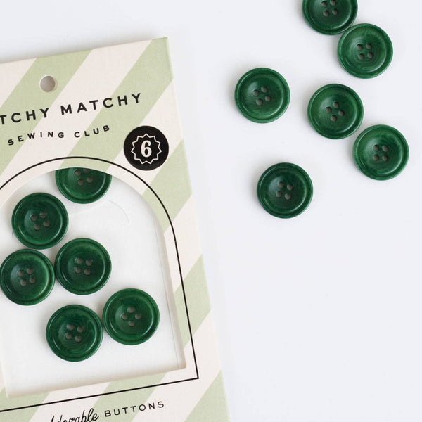 Green buttons on a card labeled 'Matchy Matchy Sewing Club' with additional buttons scattered around.
