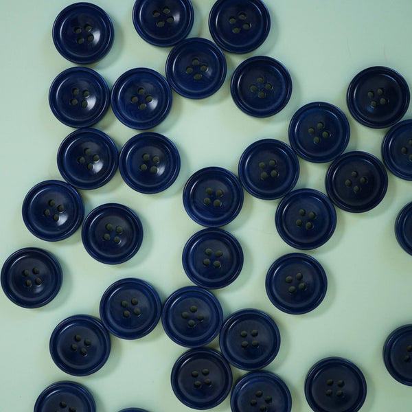 Multiple blue buttons scattered on a light green background