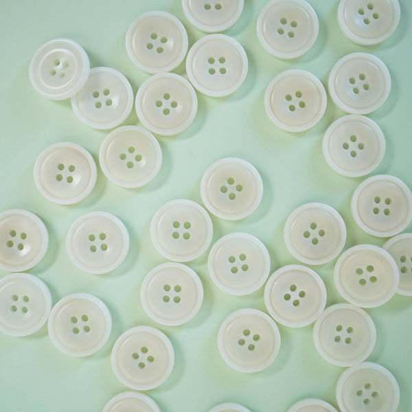 White buttons arranged in a circular pattern on a light green background