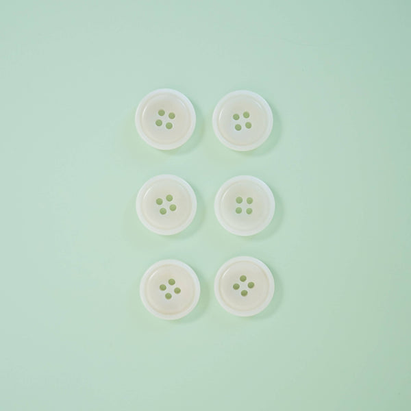 Five white buttons with green centers on a light green background