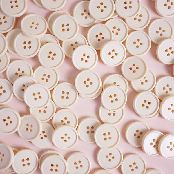 Pattern of white buttons on a pink background