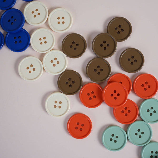 Colorful buttons arranged in a pattern on a light pink background