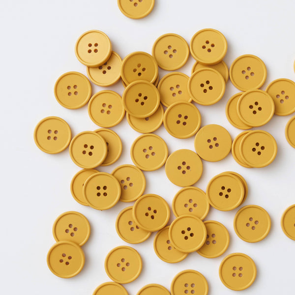 Yellow buttons scattered on a white background