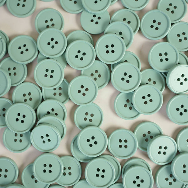 Collection of light green buttons on a beige background
