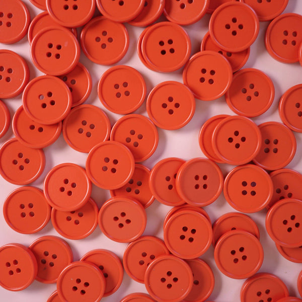Multiple orange buttons on a light pink background