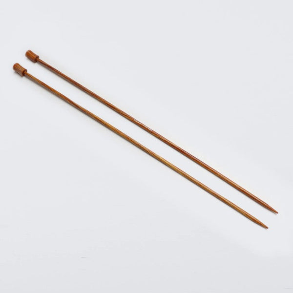 Two brown knitting needles on a white background